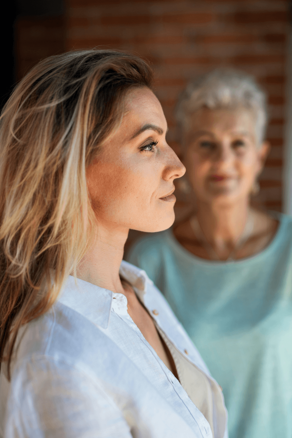 Adult daughter with mother standing in the background