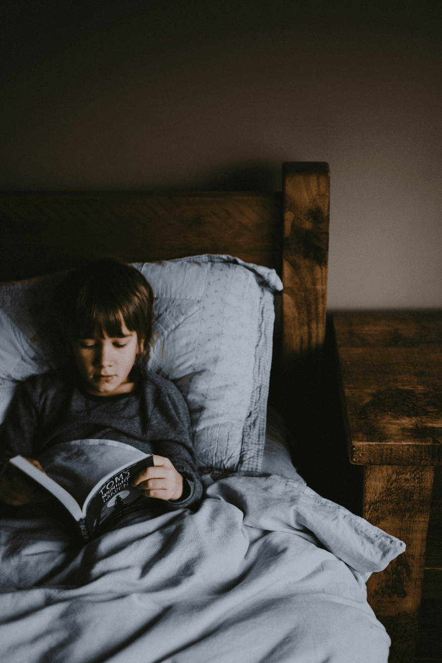 Boy reading in bed at night