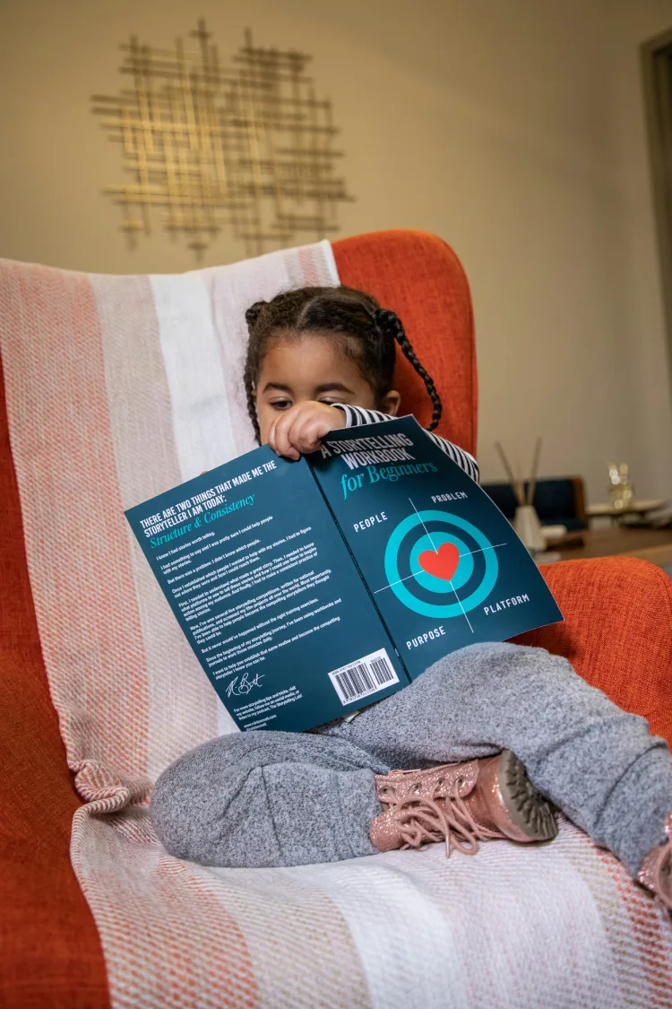 Child sitting in an armchair reading a book