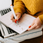Close-up of woman writing journal