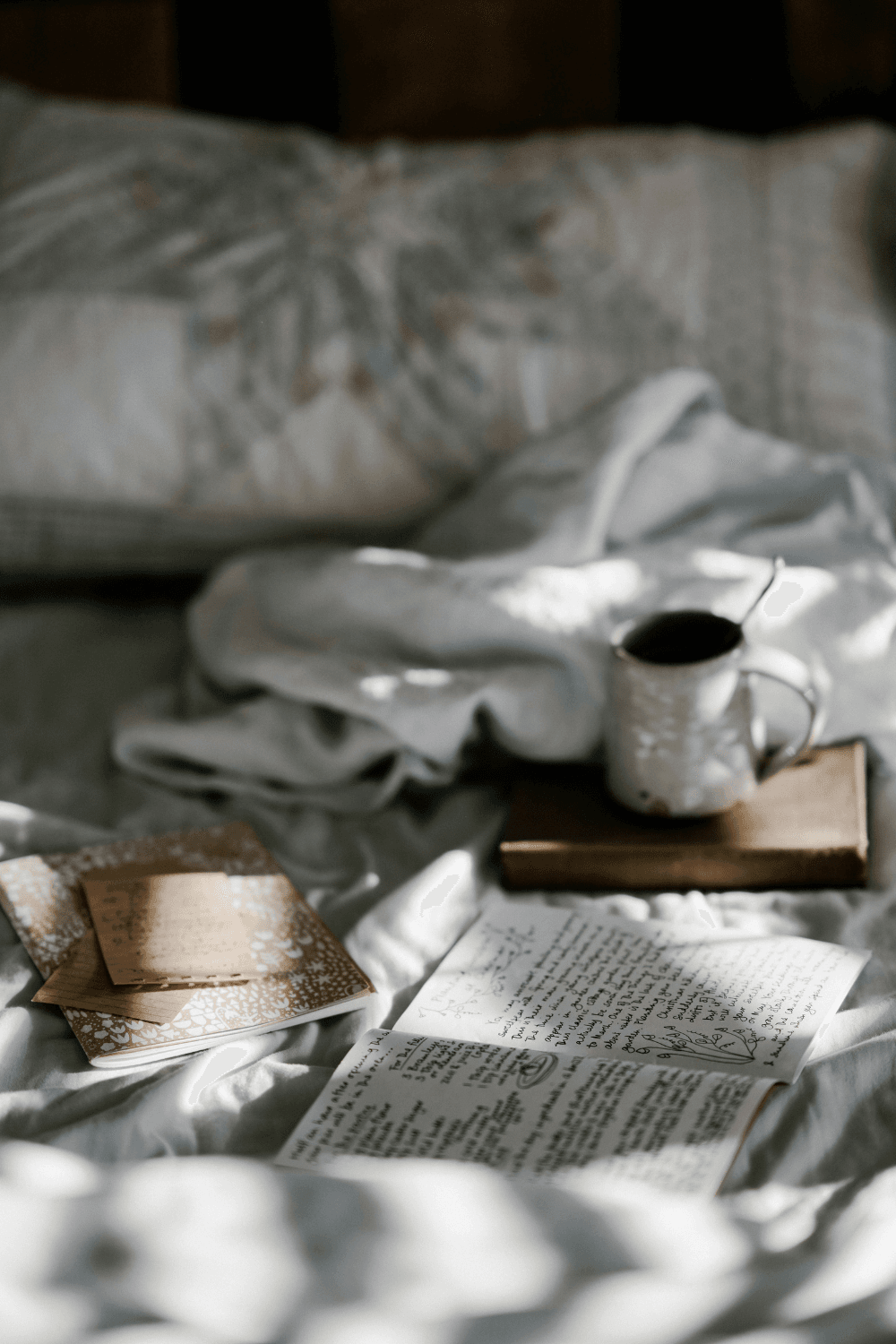 Coffee mug and books on white duvet