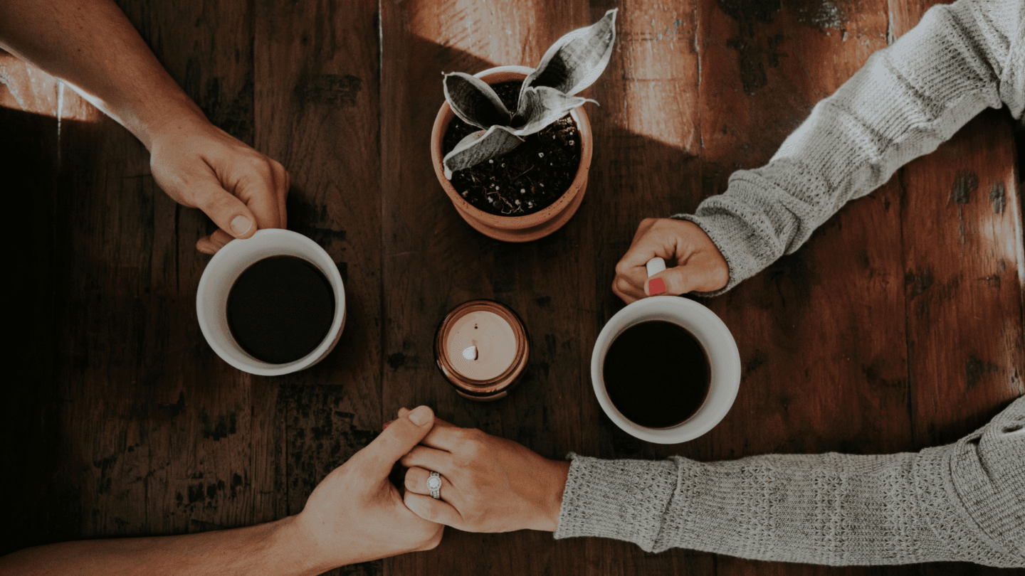 Couple holding hands across a table