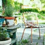 Empty mental chair in garden next to plants