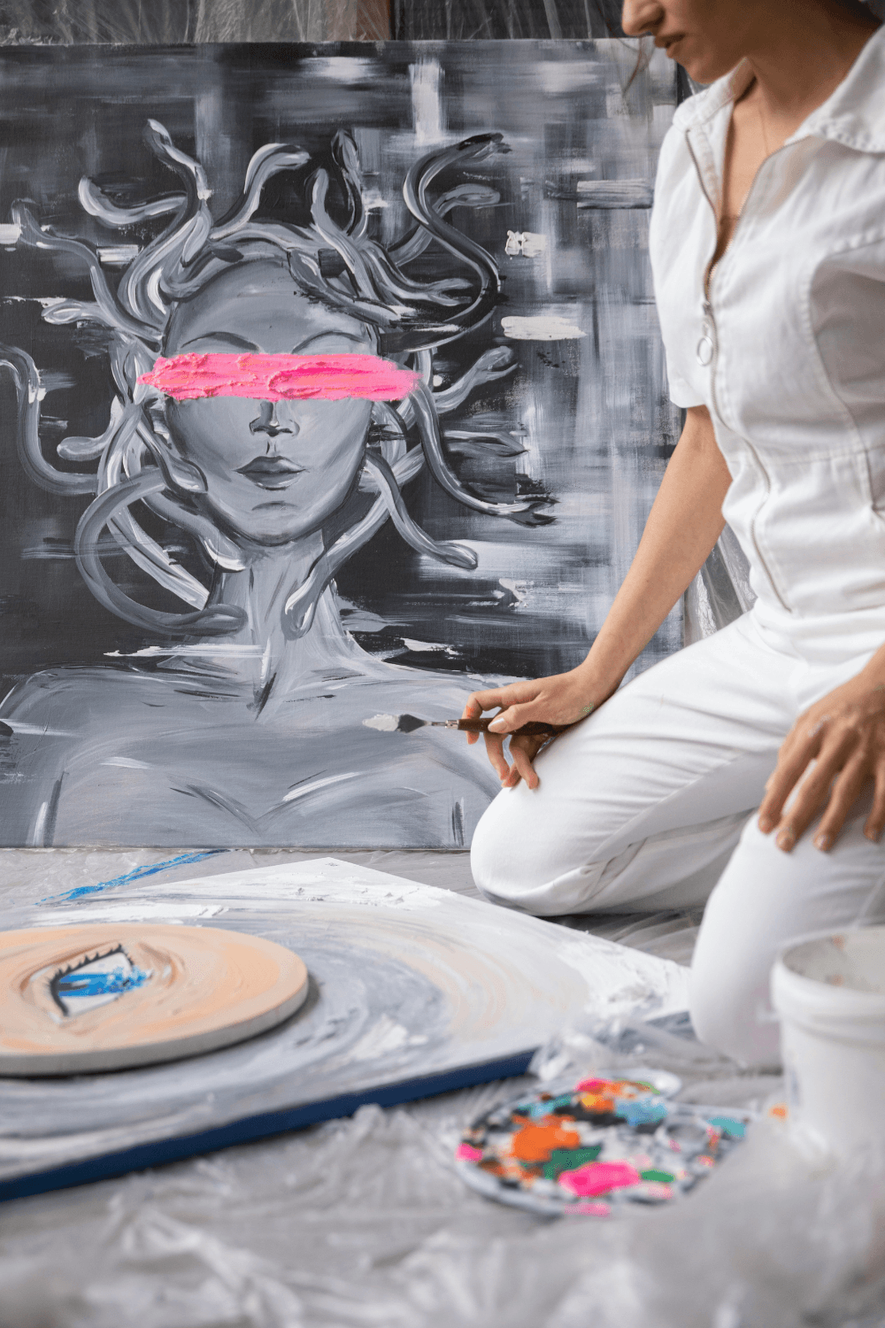 Female artist painting an image of a blue eye