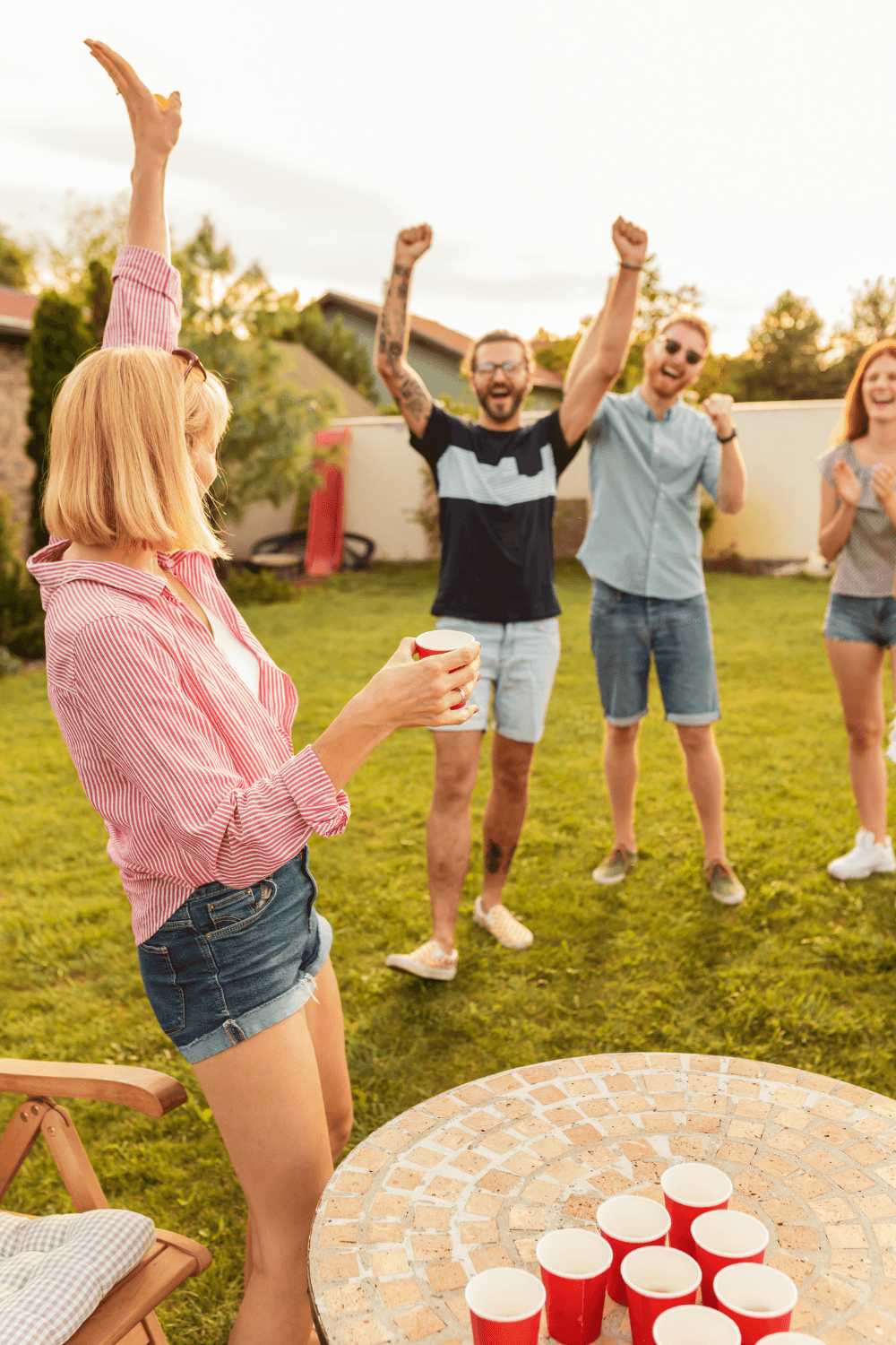 Friends playing beer pong outside in summer
