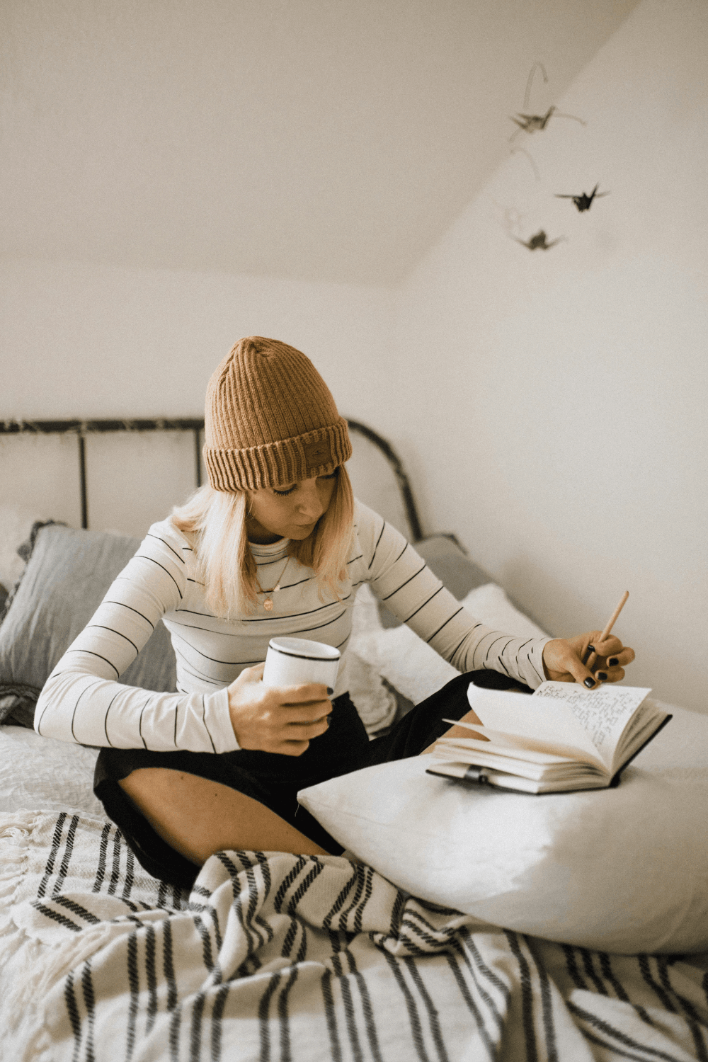 Girl sitting on bed writing in notebook