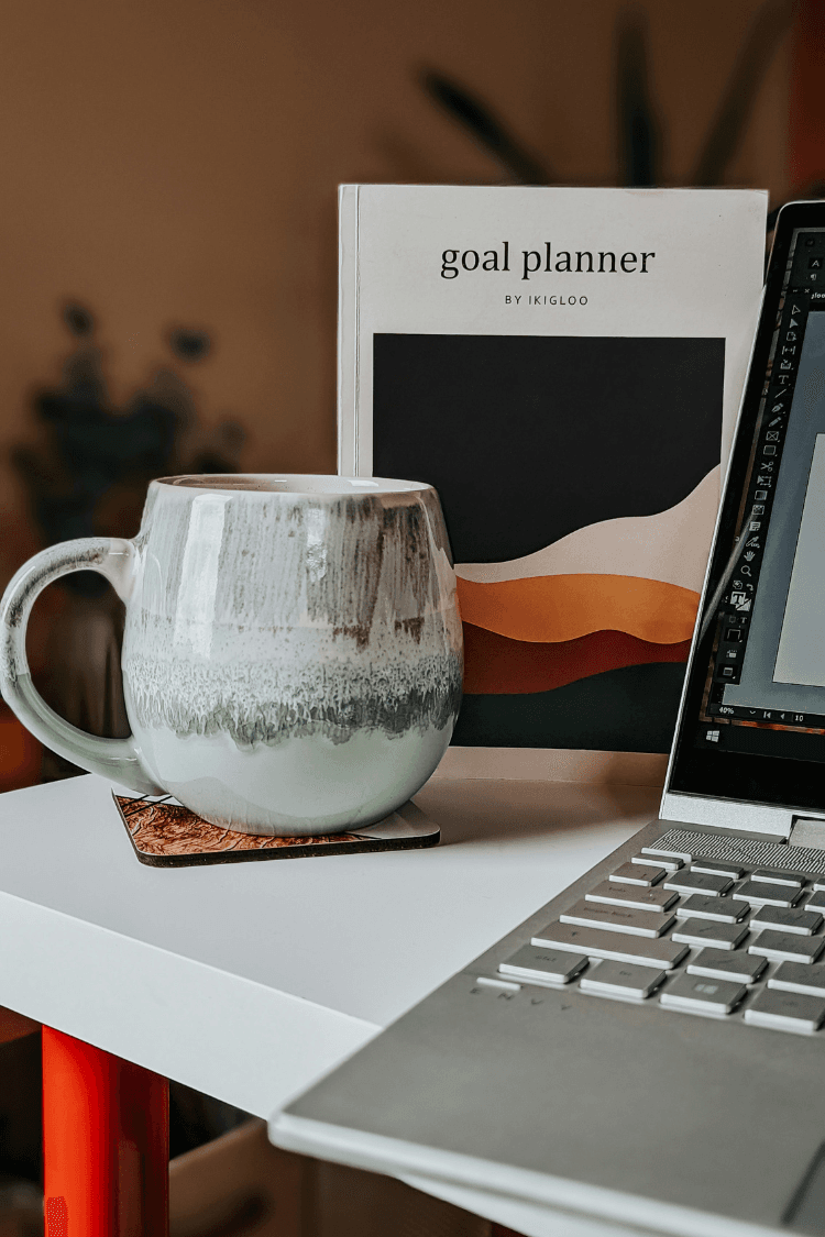 Goal planner next to mug and computer