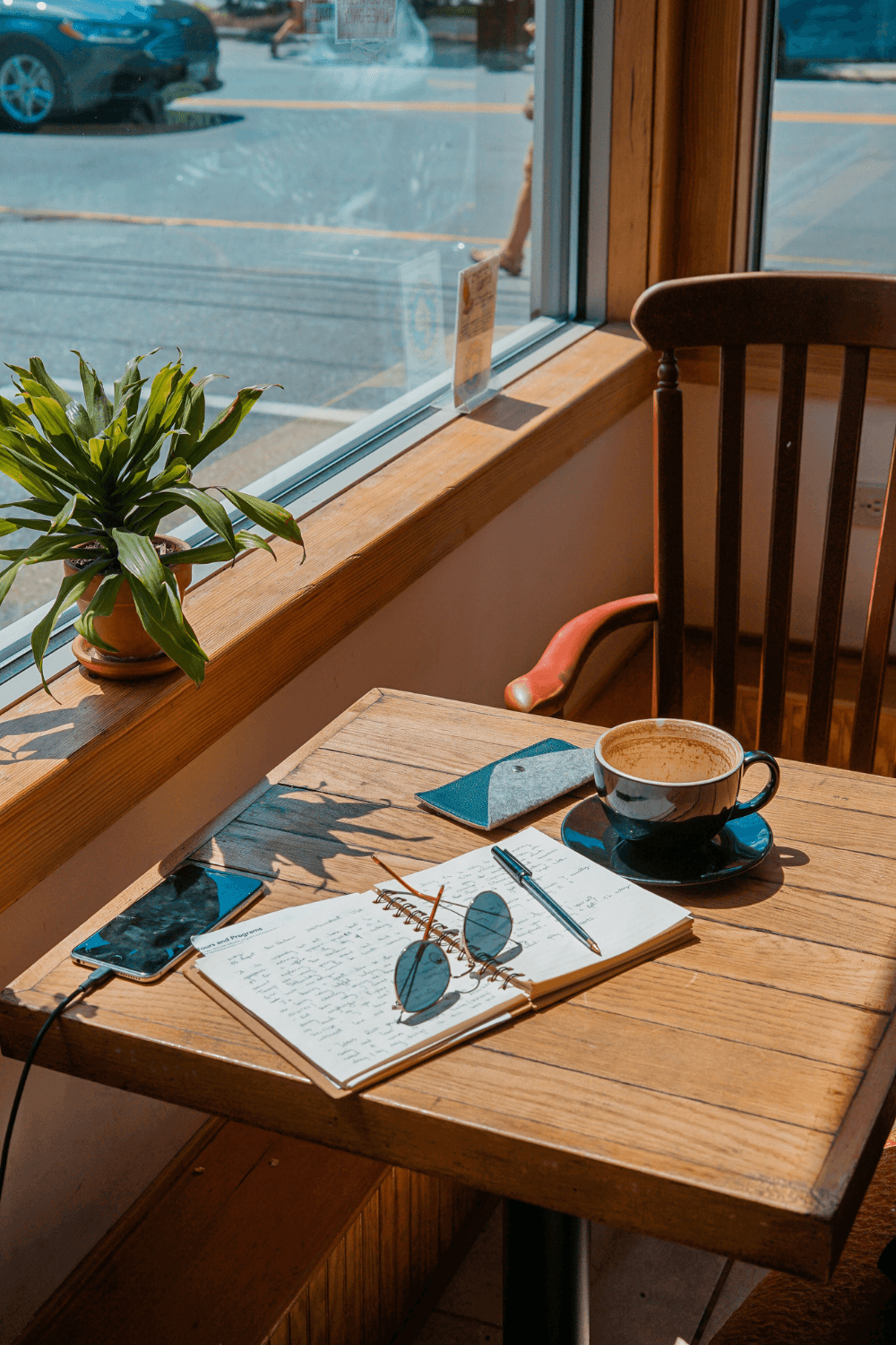Journal on a table by a coffee shop window