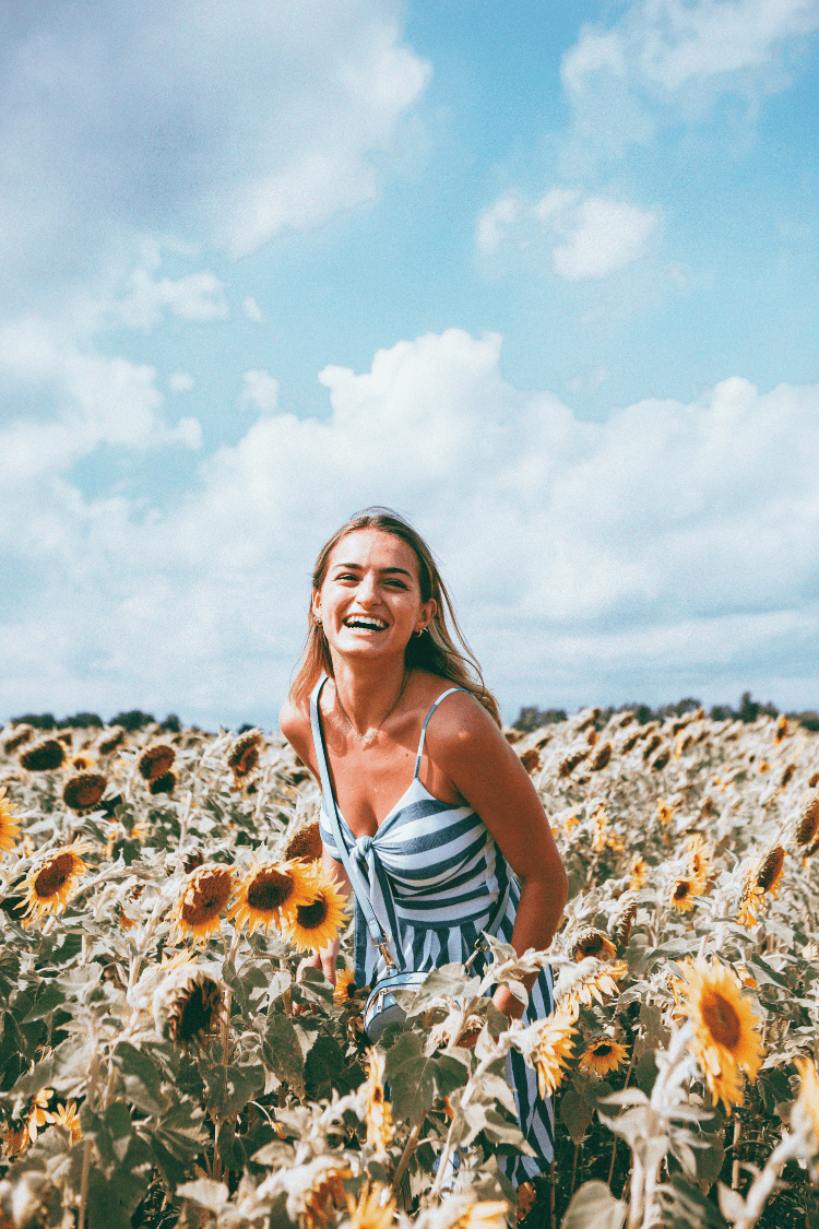 Smiling woman in field of sunflowers