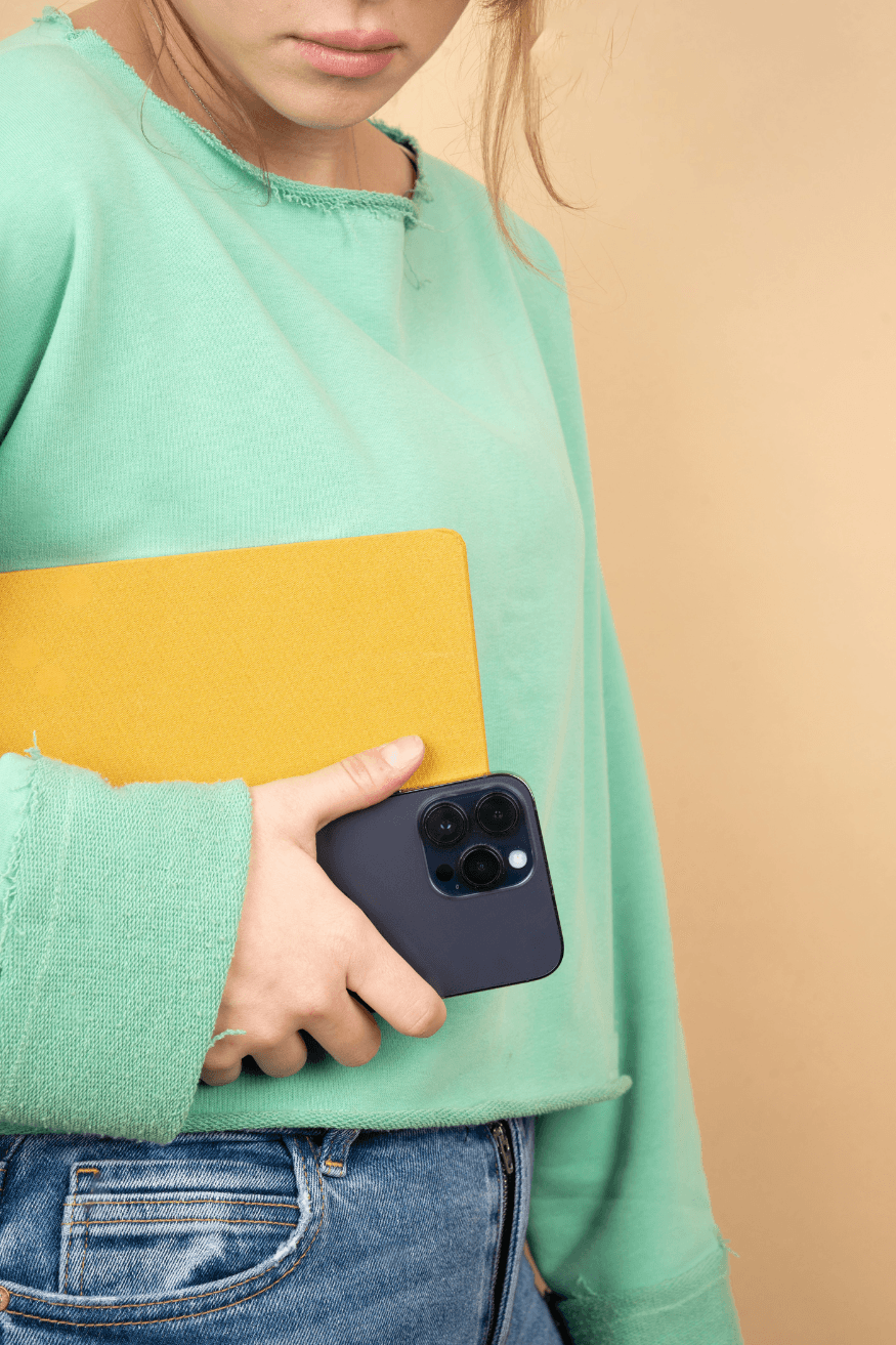 Teenage girl holding note book and mobile phone