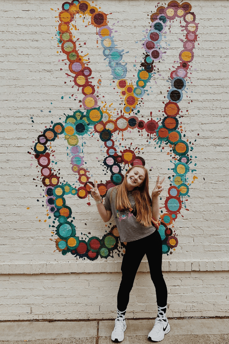 Teenager posing next to peace sign
