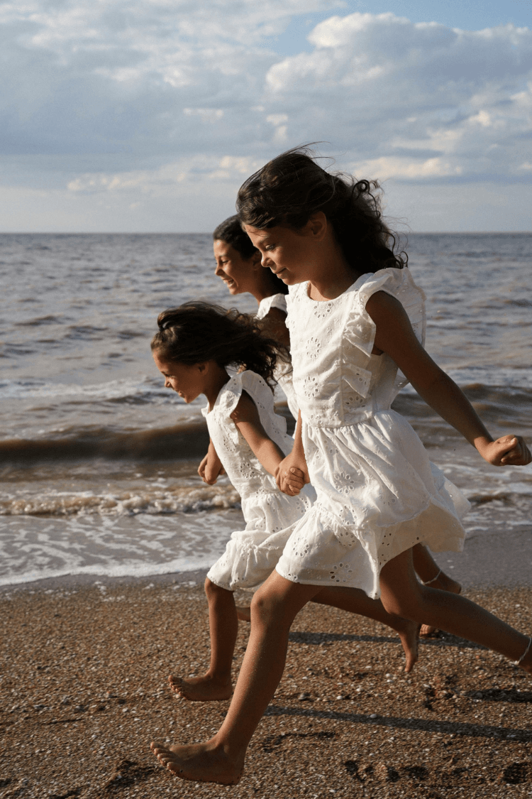 Three happy girls running along a beach