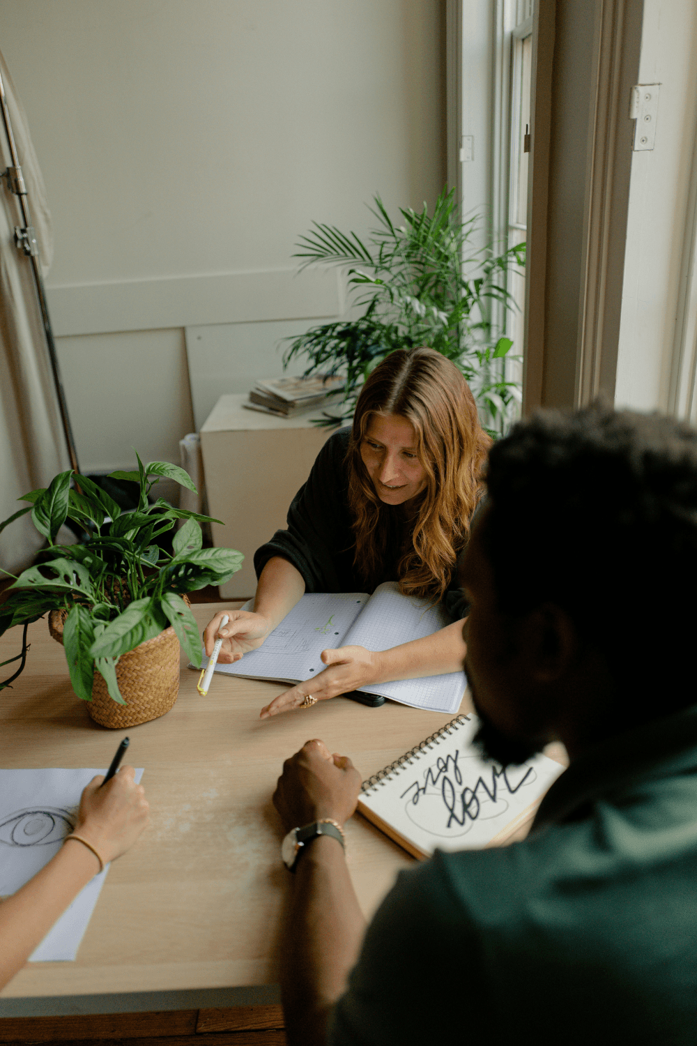 Three woman in a work meeting sharing a desk
