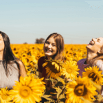 Three young woman in a field of sunflowers
