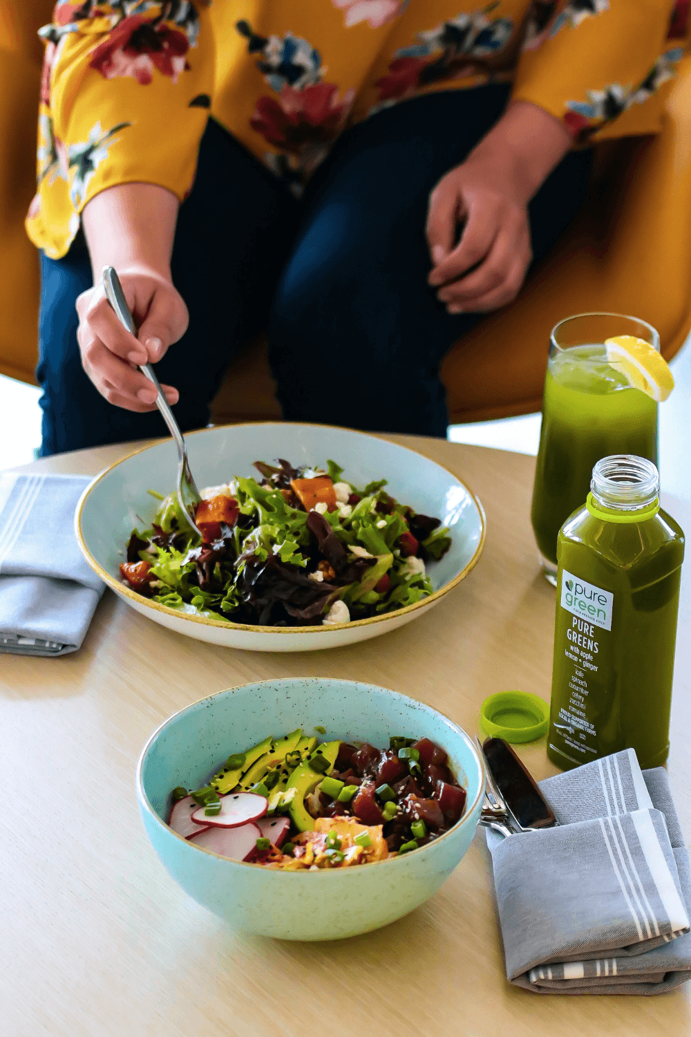Two bowls of healthy salad and glass of green juice