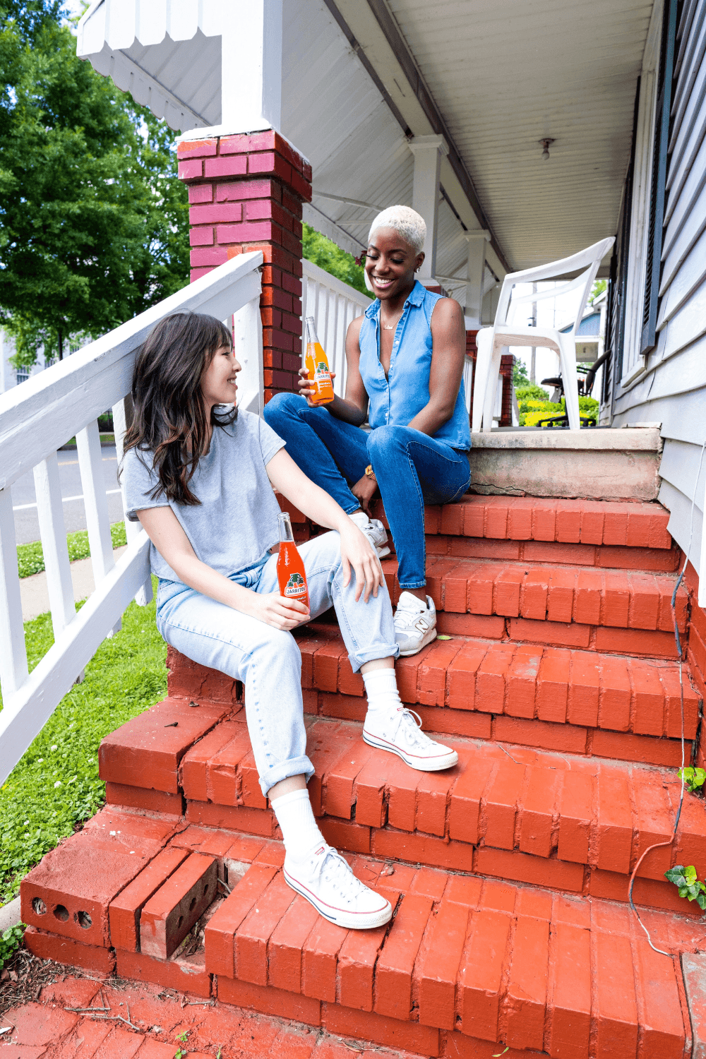 Two woman having a drink outside on the steps