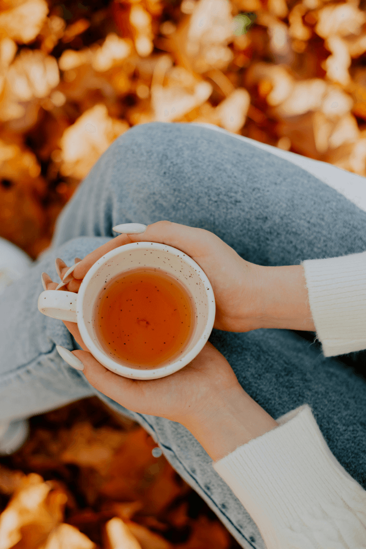 Woman holding cup of herbal tea in her hands