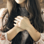 Woman holding hands across chest showing self-compassion