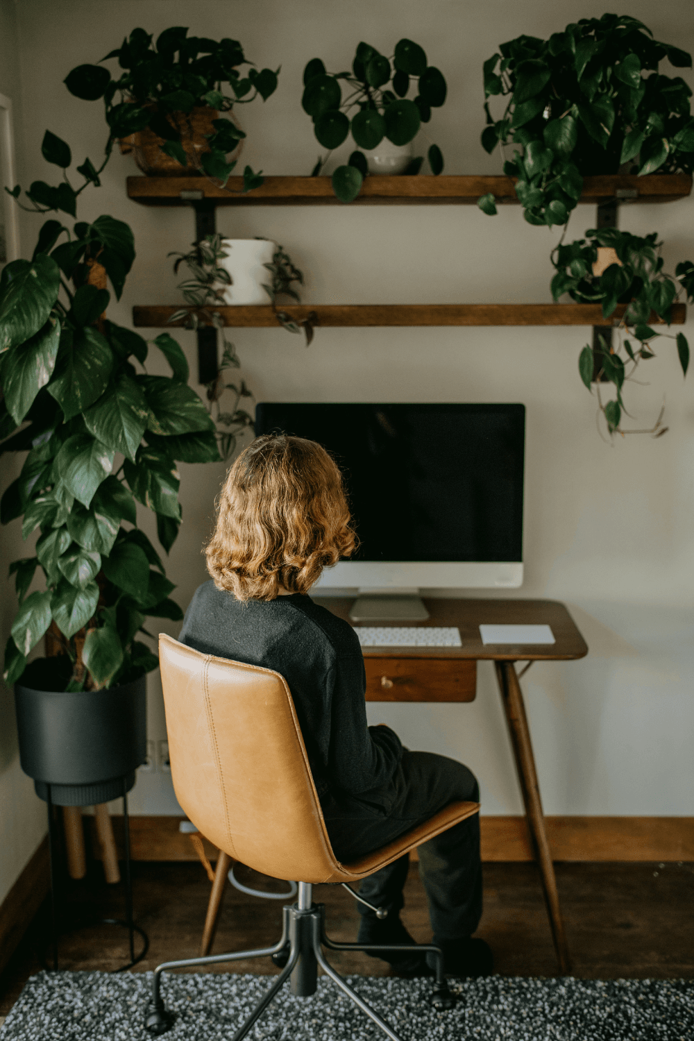 Woman looking at blank computer screen with her back to the camera