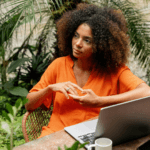 Woman wearing orange t-shirt sitting at desk