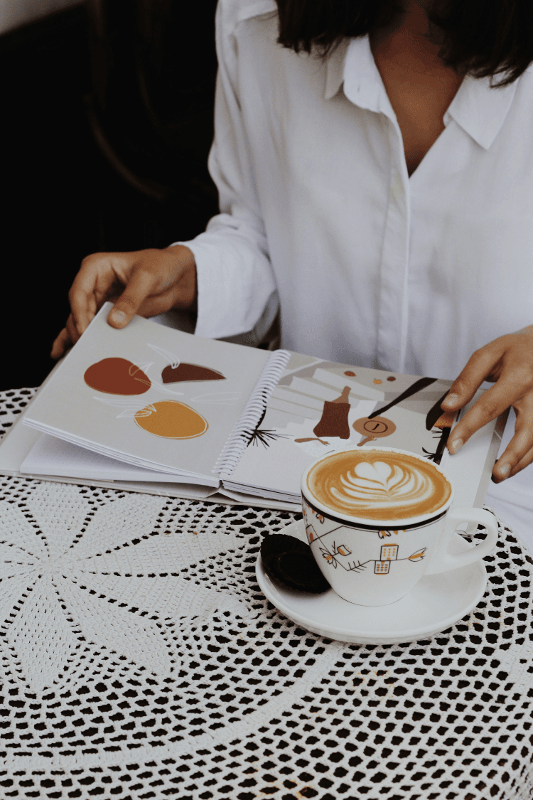 Woman wearing white shirt looking at images in book
