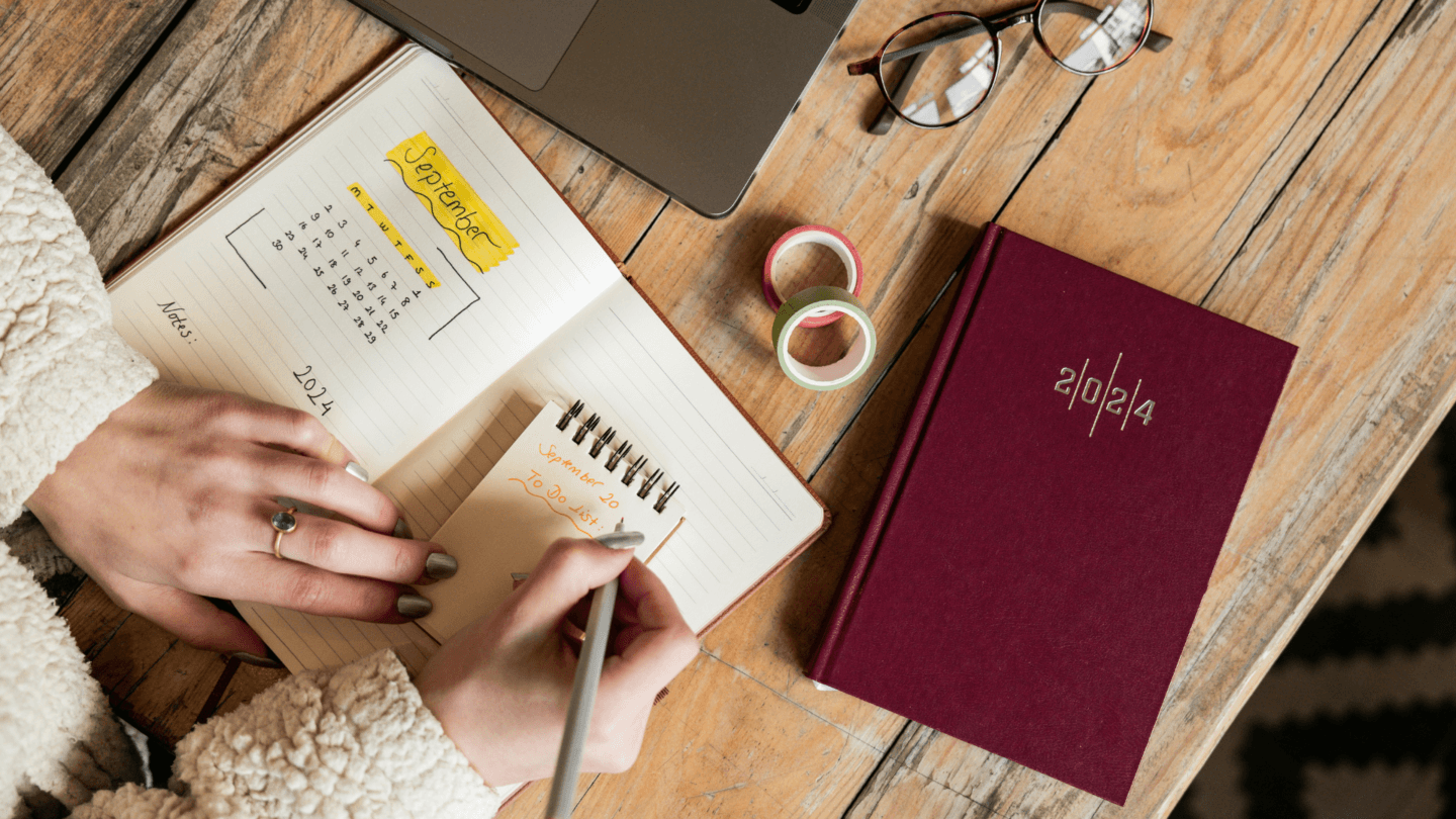 Woman writing goals and to-do list in notebook
