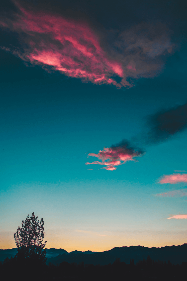 Blue and orange sky at night and pink clouds as the sun sets
