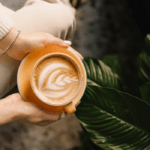 Close-up of woman in cream jumper holding cup of coffee
