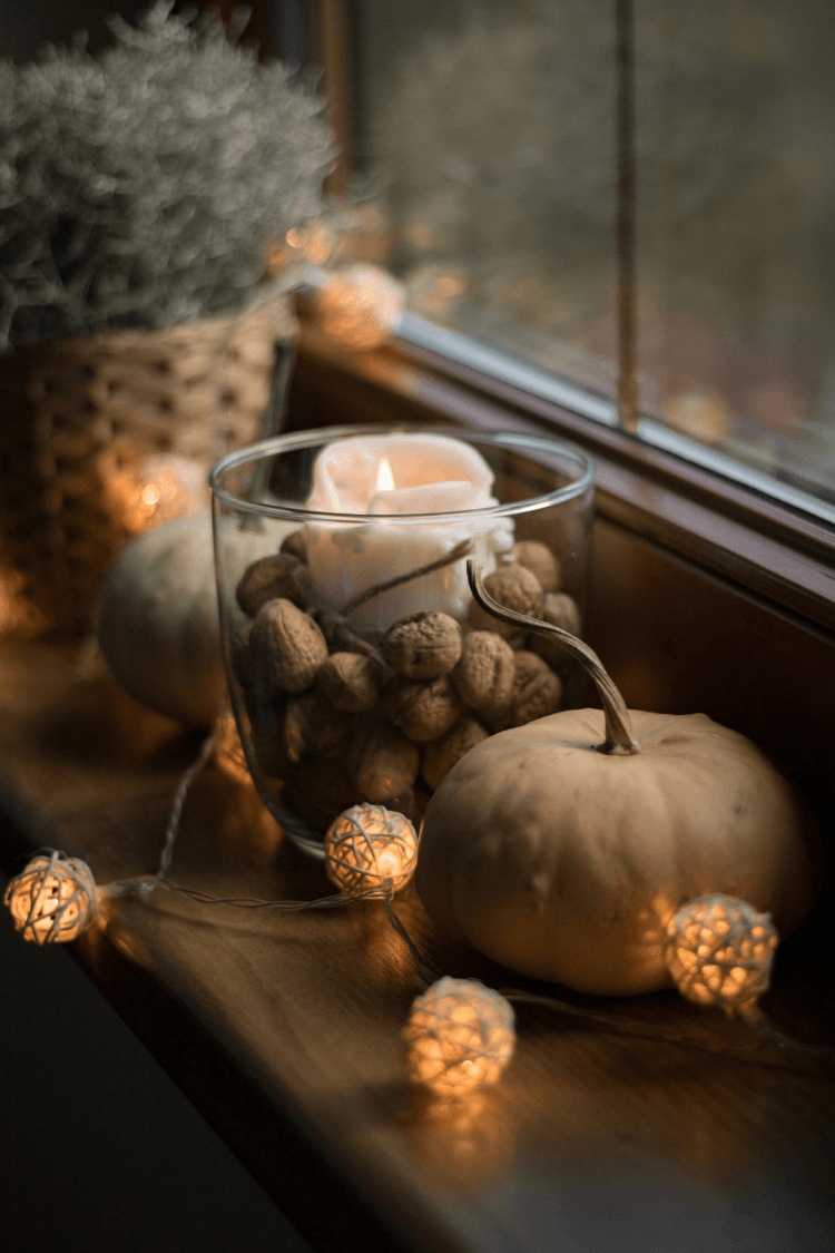 Cosy hygge sideboard with candle, lights and pumpkin