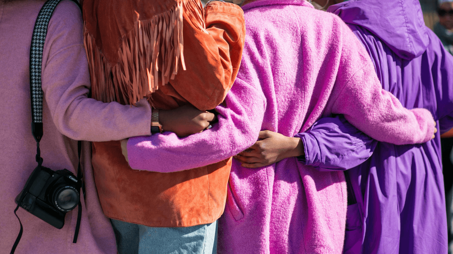 Four women with their arms around each other