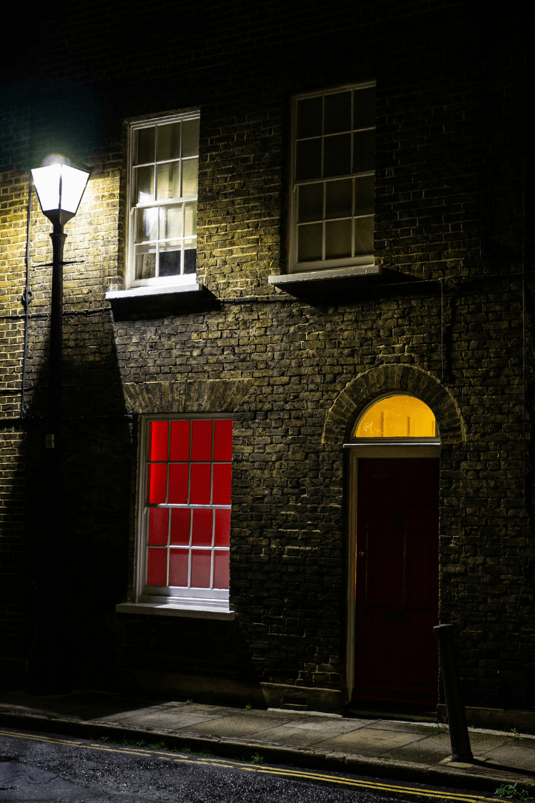 House on dark street at night with downstairs light on