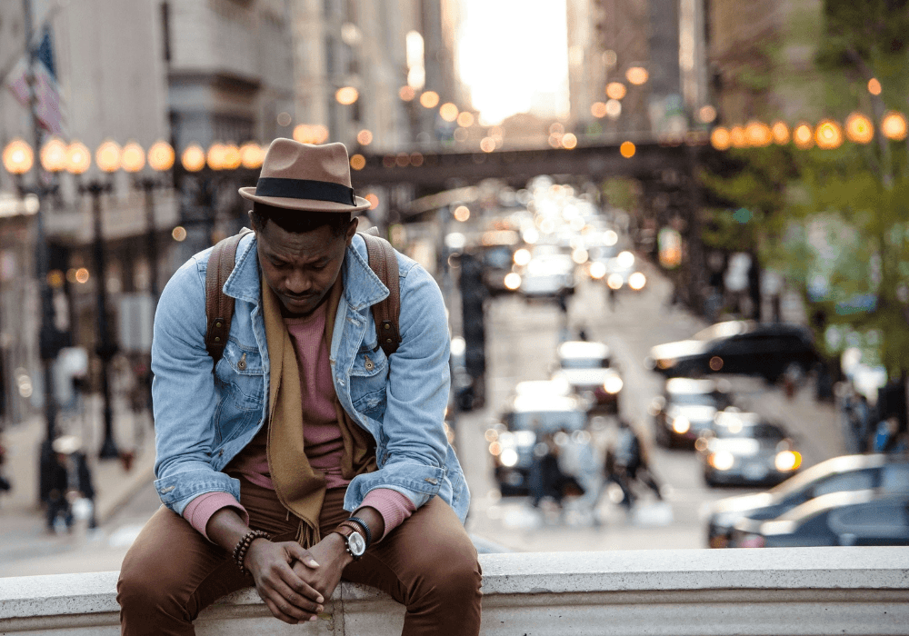 Man sitting on wall looking downcast