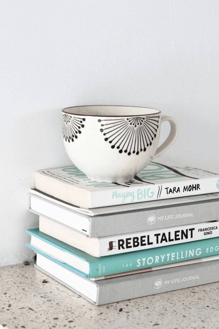Pile of books with mug on top