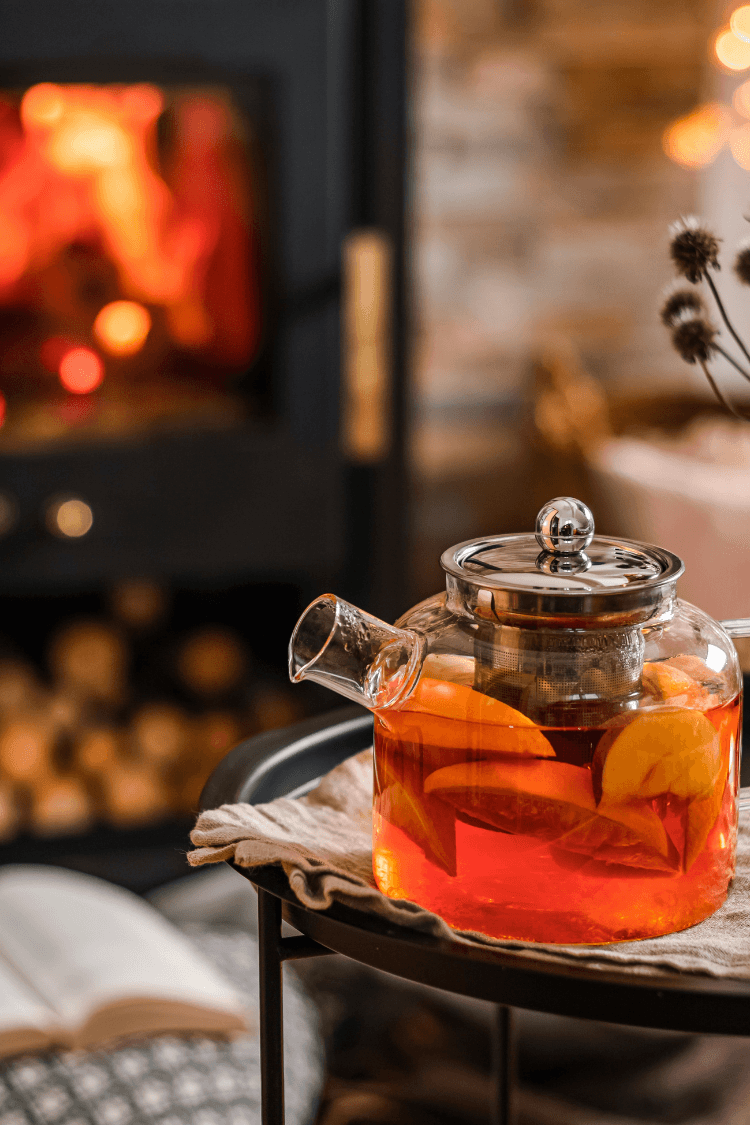 Pot of cinnamon tea next to fireplace