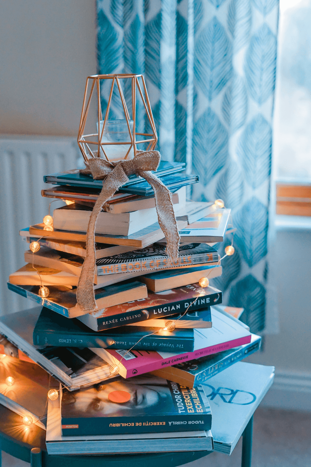 Stack of books with fairy lights on