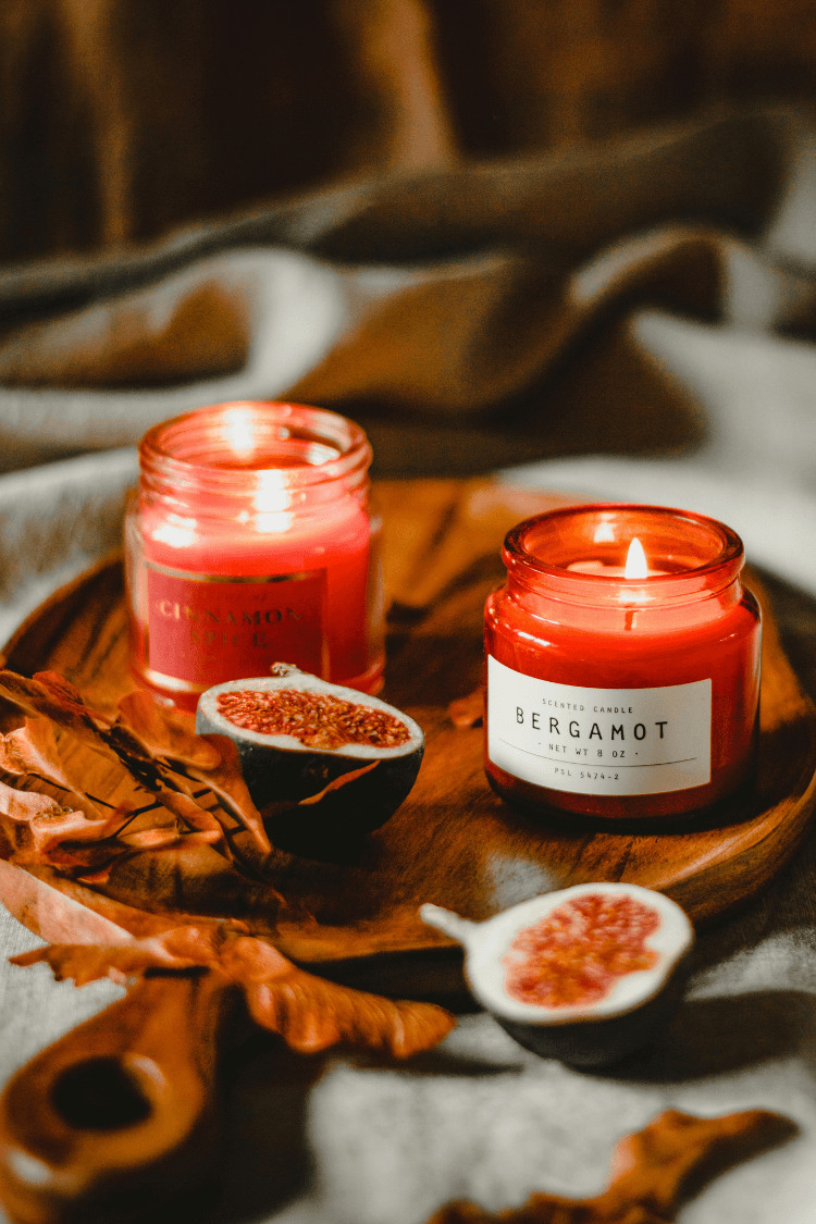 Two bergamot candles on wooden tray