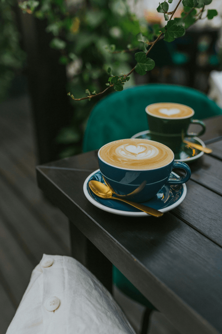 Two blue coffee cups and saucers on table in cafe