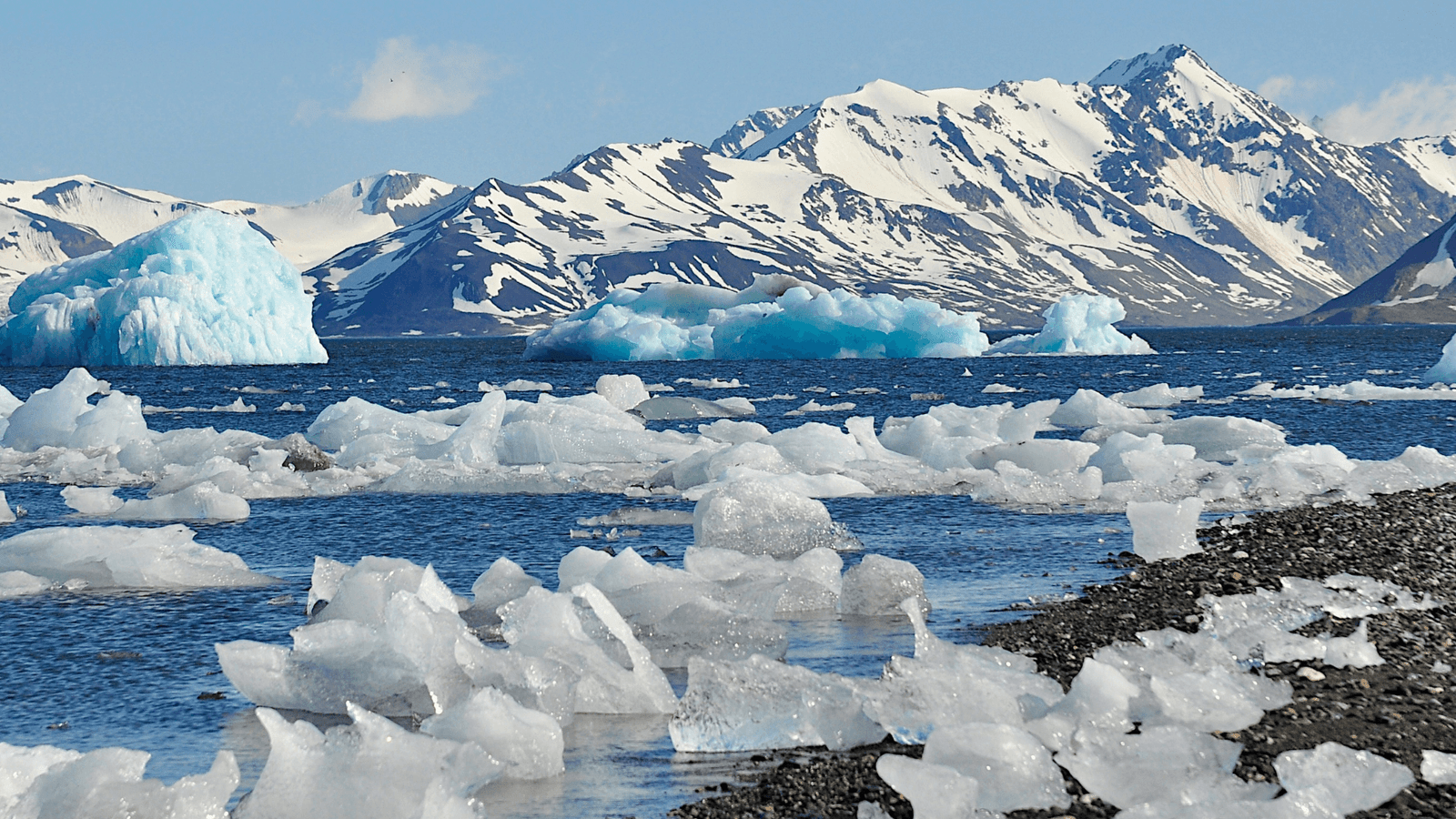 Water, ice and snow topped mountains in Svalbard