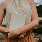 Woman holding journal on beach