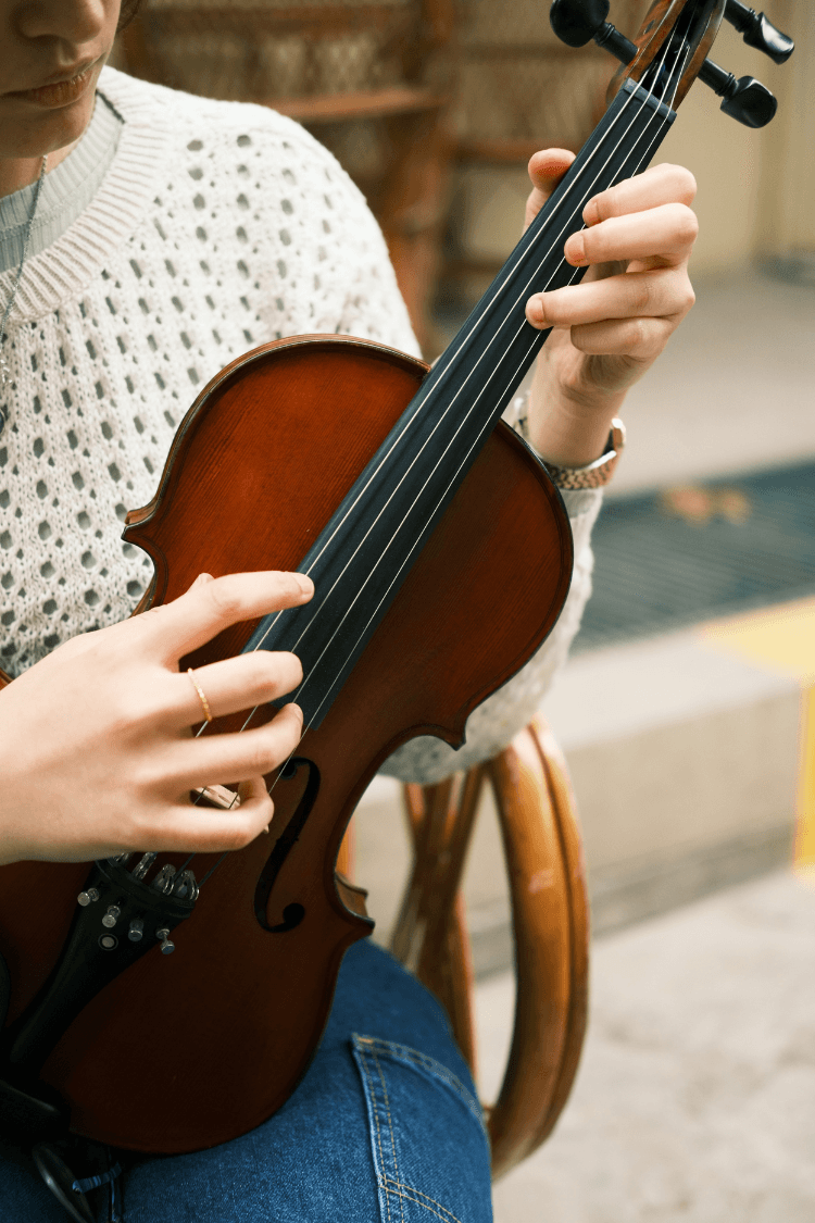 Woman holding viola looking at the strings 