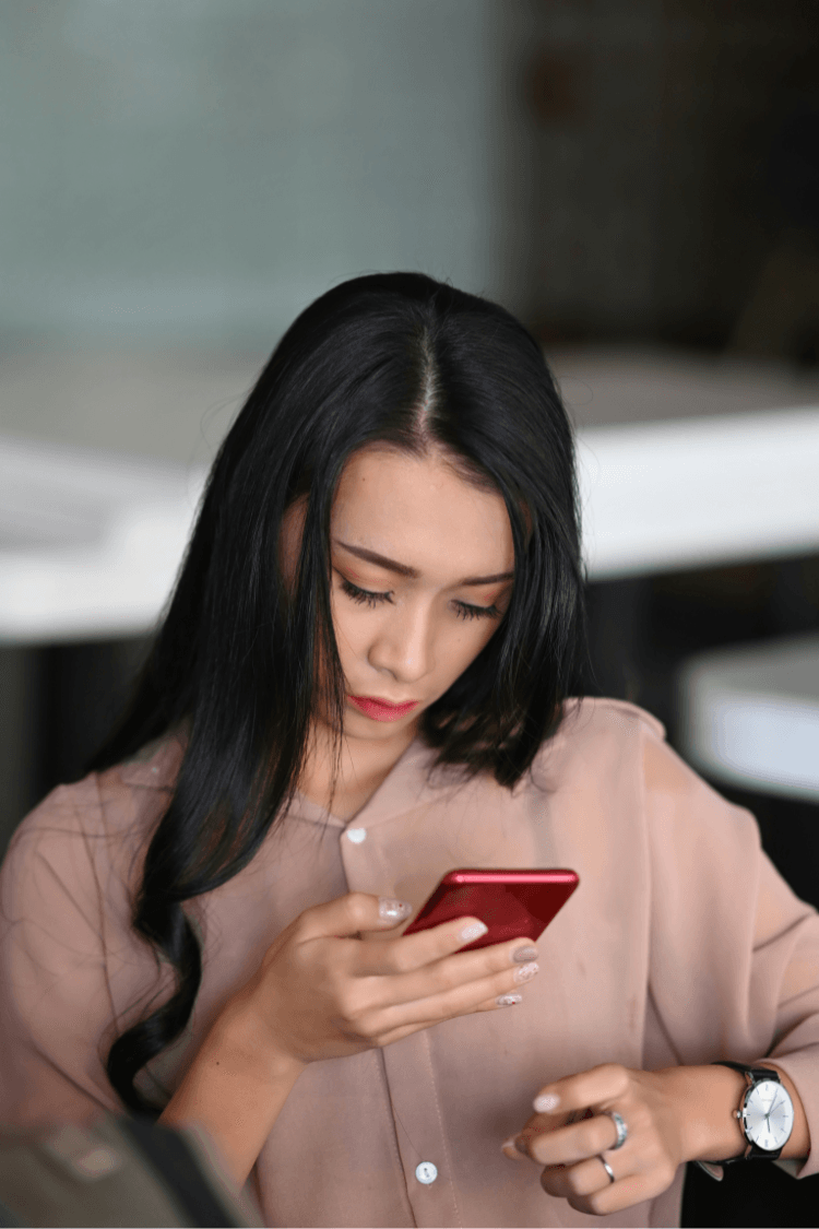 Woman looking at her smartphone with concerned expression