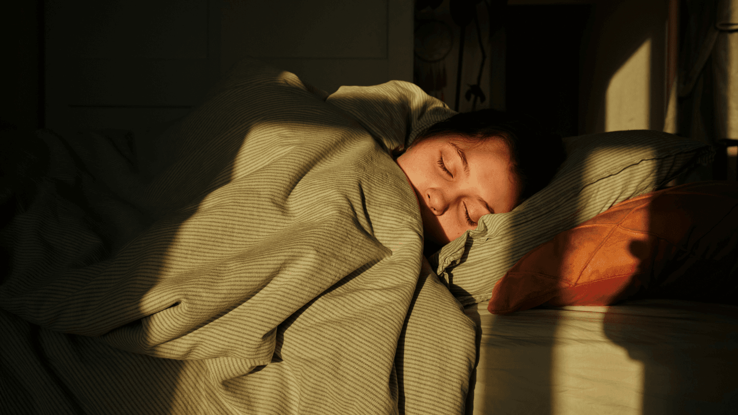 Woman lying under duvet in bed
