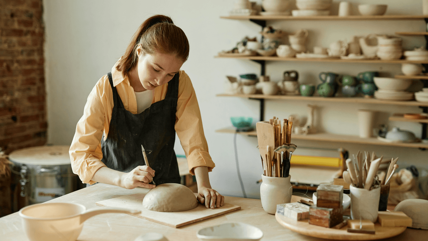 Woman making pottery in studio
