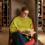 Woman sitting in library reading a book