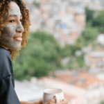 Woman with face mask on holding mug