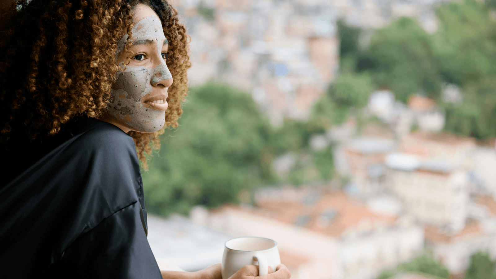 Woman with face mask on holding mug