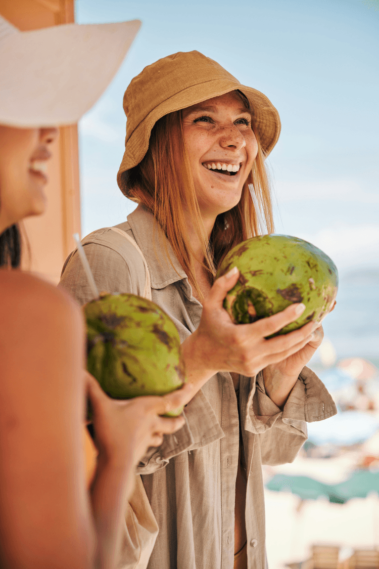 Women on holiday drinking out of watermelons