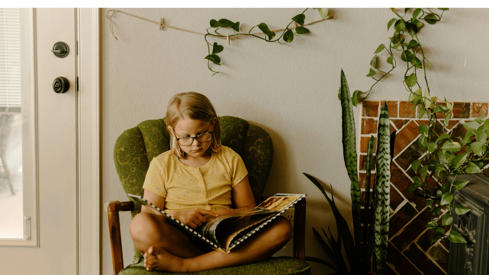 Young girl in yellow t-shirt reading a large book