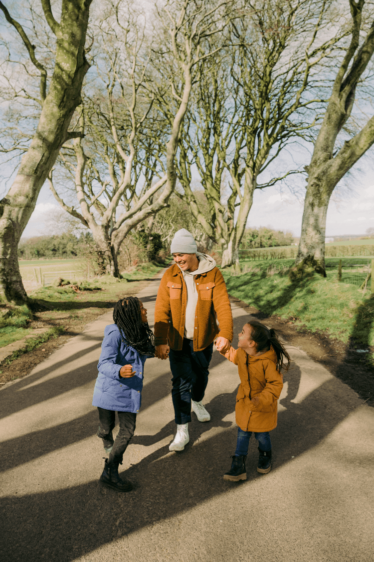Father walking along path with two daughters
