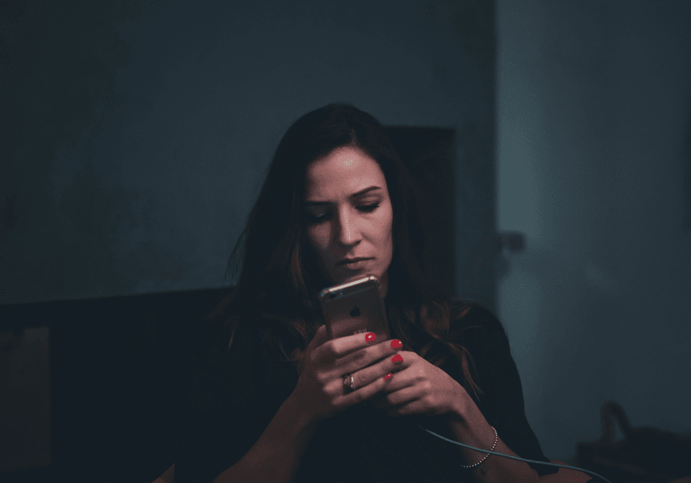 Woman scrolling smartphone in the dark